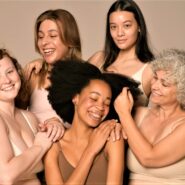 Imagem de um grupo de cinco mulheres diversas em um fundo bege.